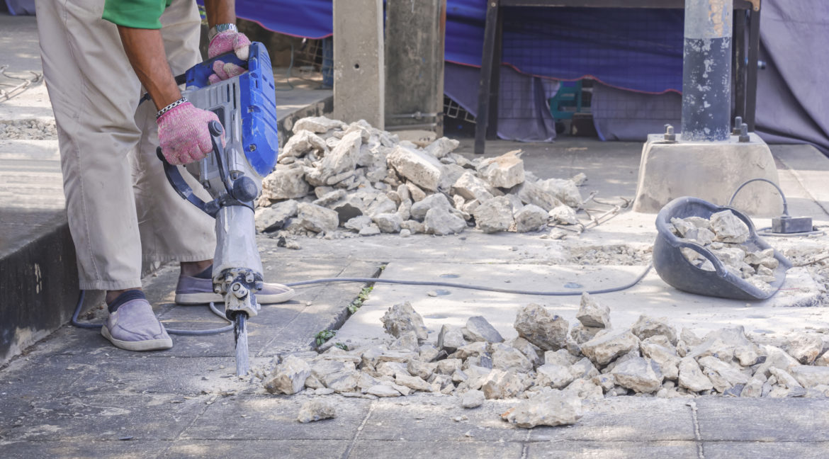 road-worker-using-jackhammer-drilling-footpath-for-2023-01-03-21-13-44-utc