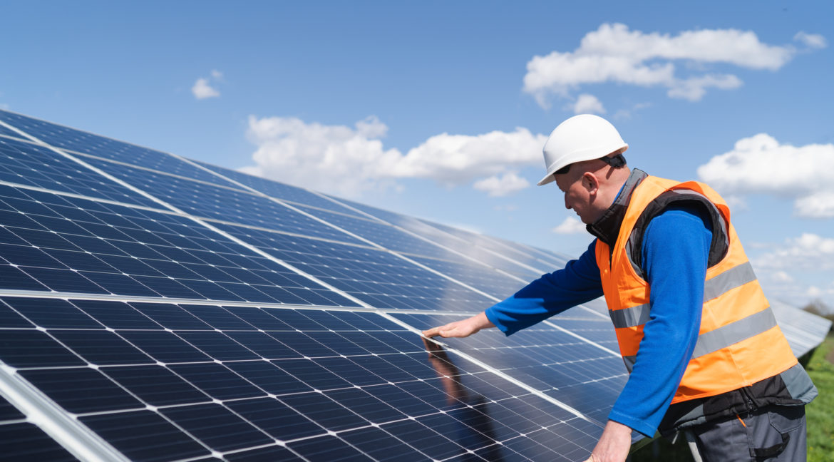 Solar power plant engineer makes a visual inspection of solar panels