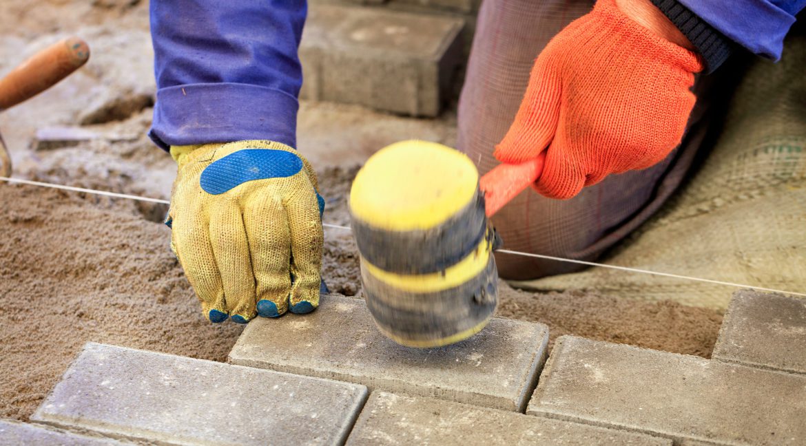 Worker lay the paving slab with special hammers