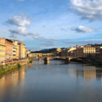 Panoramic view of Florence, Italy, featuring the historic Ponte Vecchio bridge over the Arno River after downsizing to this vibrant retirement destination. Shoket Properties.